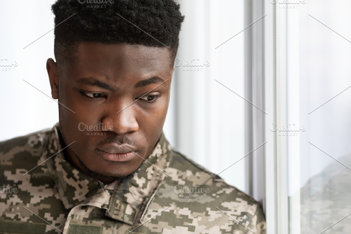 Unhappy military black man standing next to window, a Photo by Prostock-Studio (Photo 1 of 7)
