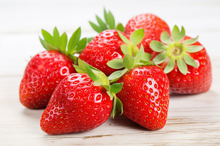 Red ripe strawberries on white wooden background, a Food & Drink Photo by AlyaAnd