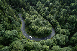 White car driving winding road throu, a Photo by Pixeness Studio
