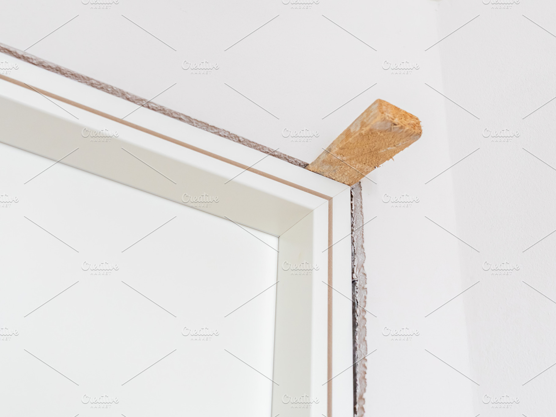 Construction worker installing new interior door frame, an Architecture Photo by Antonio Gravante Market