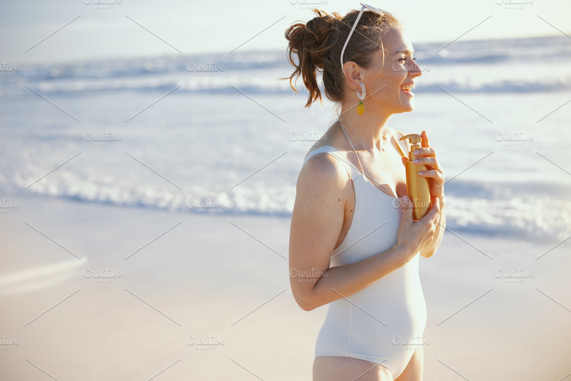 smiling stylish female in white swimwear with spf at beach, a Person Photo by Alliance Images