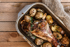 Oven baked turkey leg with potato and spices rustic style top view featuring