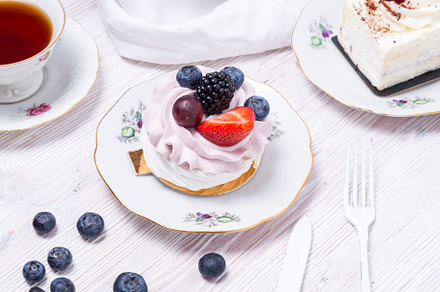 Piece of berry cake decorated with fresh berries on wooden backg, a Food & Drink Photo by MDBildes