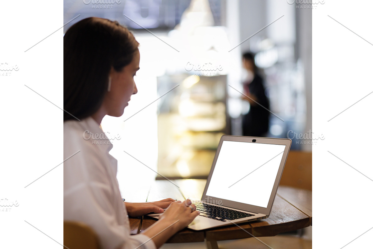 Young pretty woman using laptop in, a Device Mockup by serkum (Photo 1 of 2)