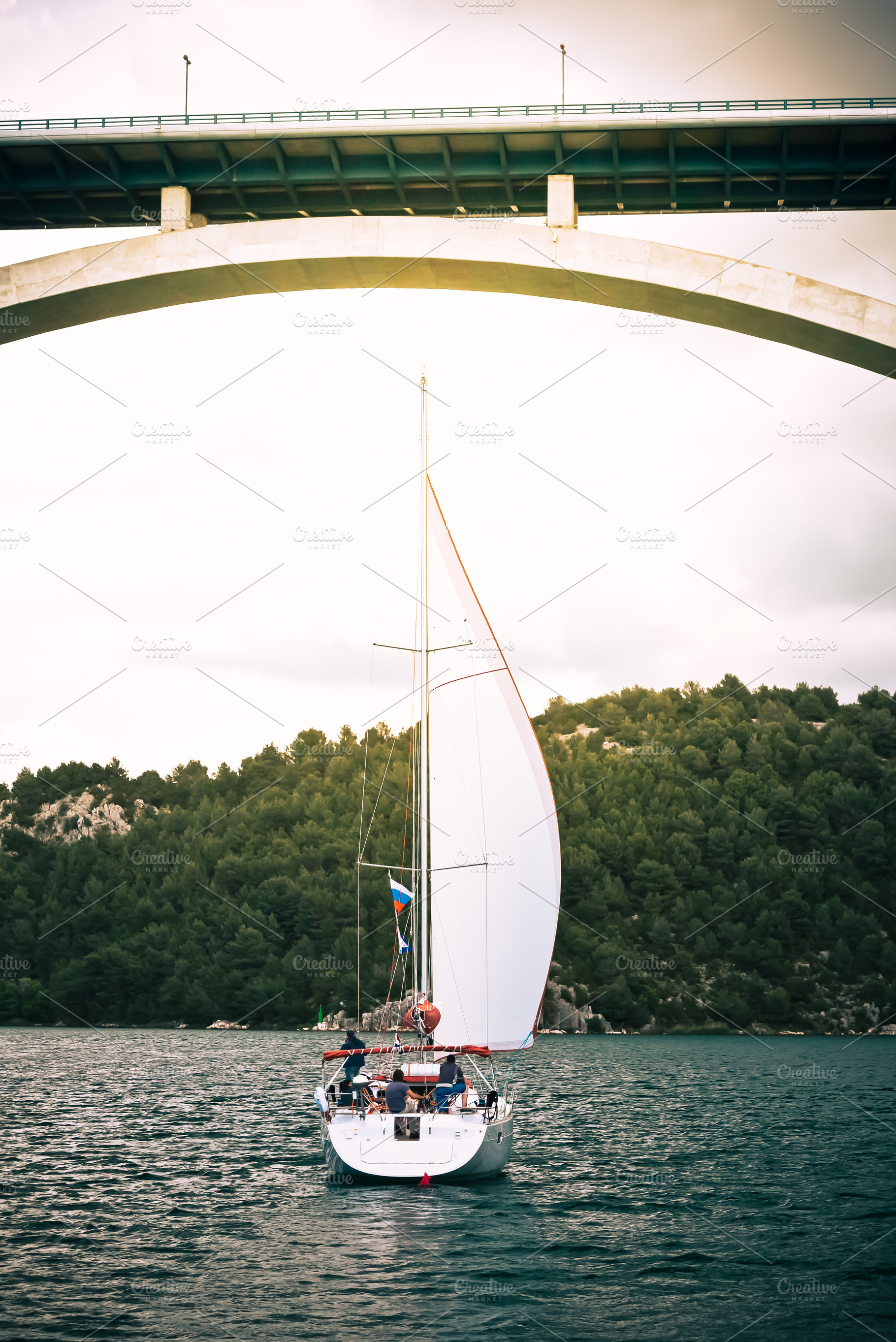 Sailboat under arch bridge on calm, a Photo by Dvoevnore photos