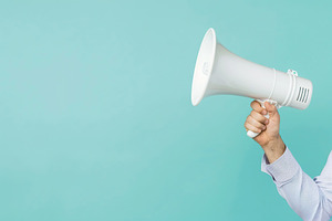 Male hand holding modern megaphone on blue background, a Photo by AlyaAnd