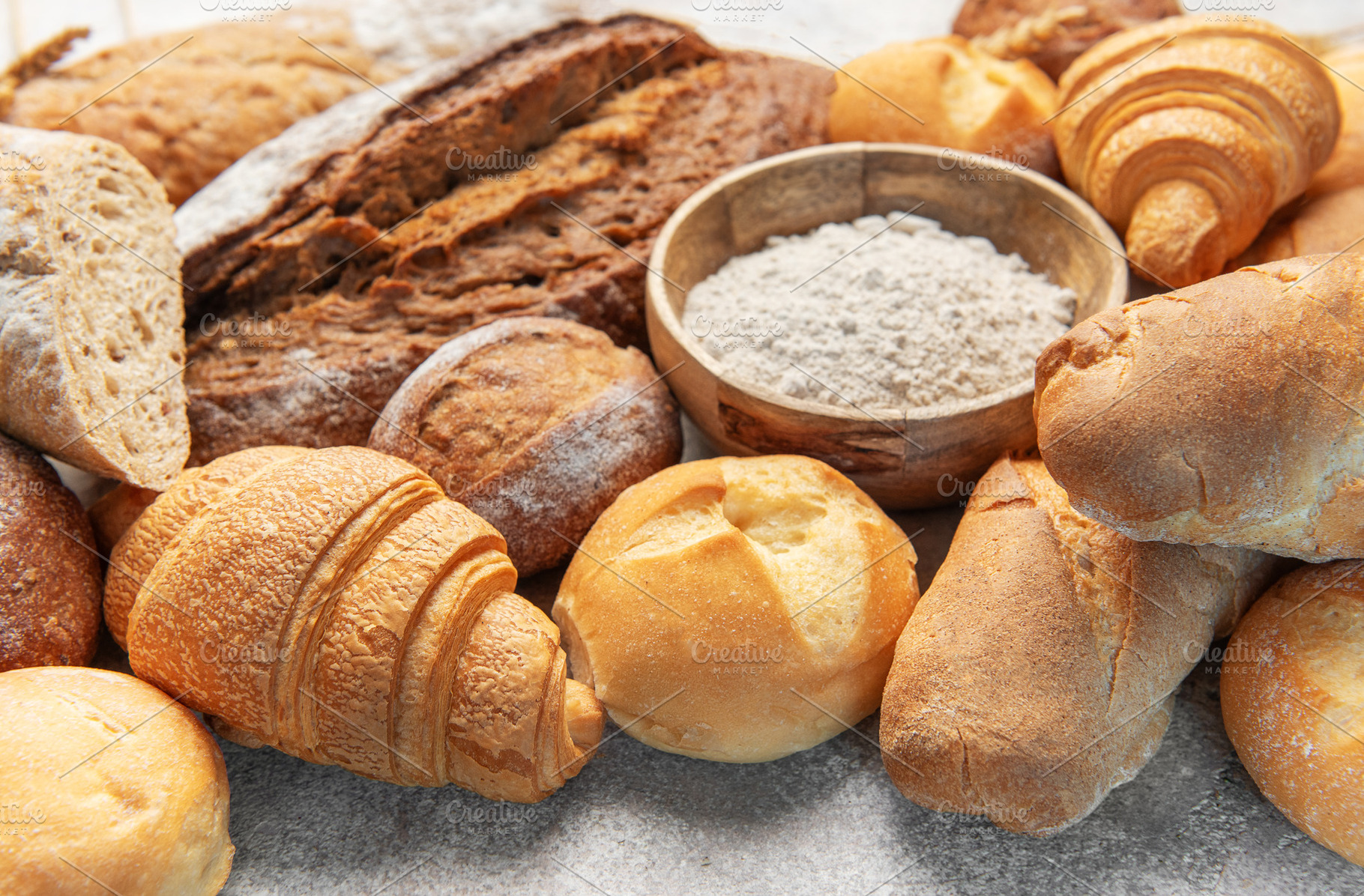 Freshly baked bread and pastries with baking flour, a Food & Drink Photo by Olena Rudo