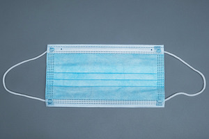 Disposable blue medical face mask on a grey background. Protective 3-ply surgic, a Health & Medical Photo by Rohan Photography