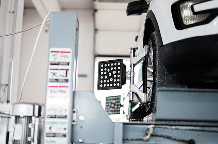 Close-up of car wheel alignment process in a modern garage, a Transportation Photo by AS photostudio