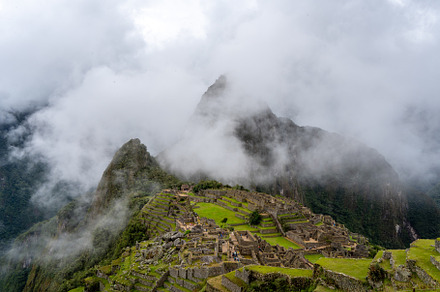 Panoramic view of Machu Picchu ruins surrounded by misty mountai