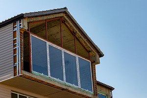 Unfinished house balcony with exposed steel frame and large glass windows under, an Architecture Photo by Ales Munt