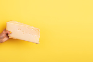 Woman’s hand with yellow nail polish holding a large wedge of, a Food & Drink Photo by Ales Munt