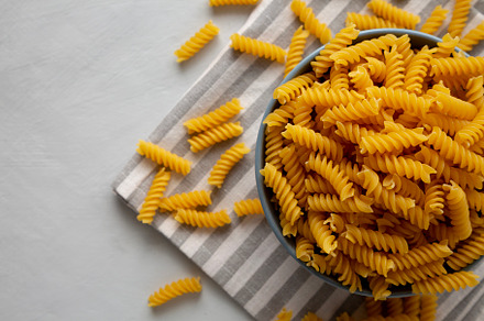 Dry Fusilli Pasta in a Bowl, top view. Flat lay, overhead, from, a Food & Drink Photo by LiudmylaChuhunova