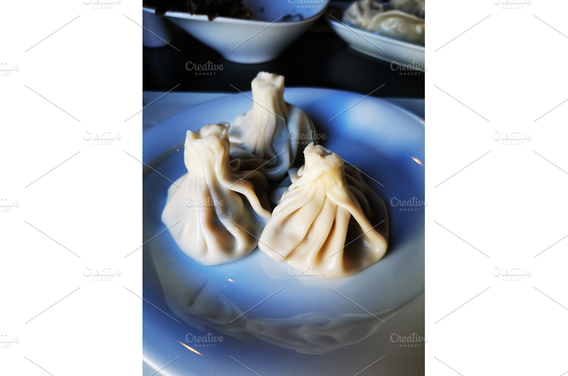Khinkali served on white plate, a Food & Drink Photo by sceptical cactus
