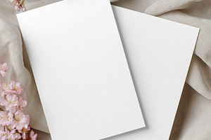 Blank paper cards mockup with pink cherry blossoms on soft draped silk fabric c, a Holiday Photo by Studio ANNA