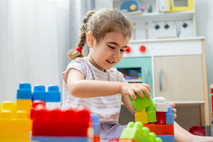 Little girl building colorful block tower on floor at home, a Person Photo by etorres69