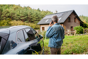 Man charging electric car in front, a Transportation Photo by HalfPoint