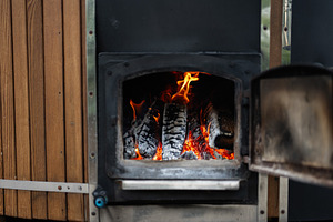 Burning Firewood in a Rustic Outdoor Stove for Warmth and Coziness, a Photo by AS photostudio