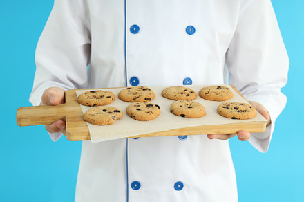 Concept of cooking, young male chef with board of cookies, a Person Photo by AtlasStudio PRO