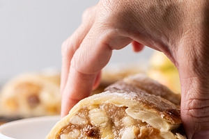 Hand taking two piece of apple strudel, a Food & Drink Photo by etorres69