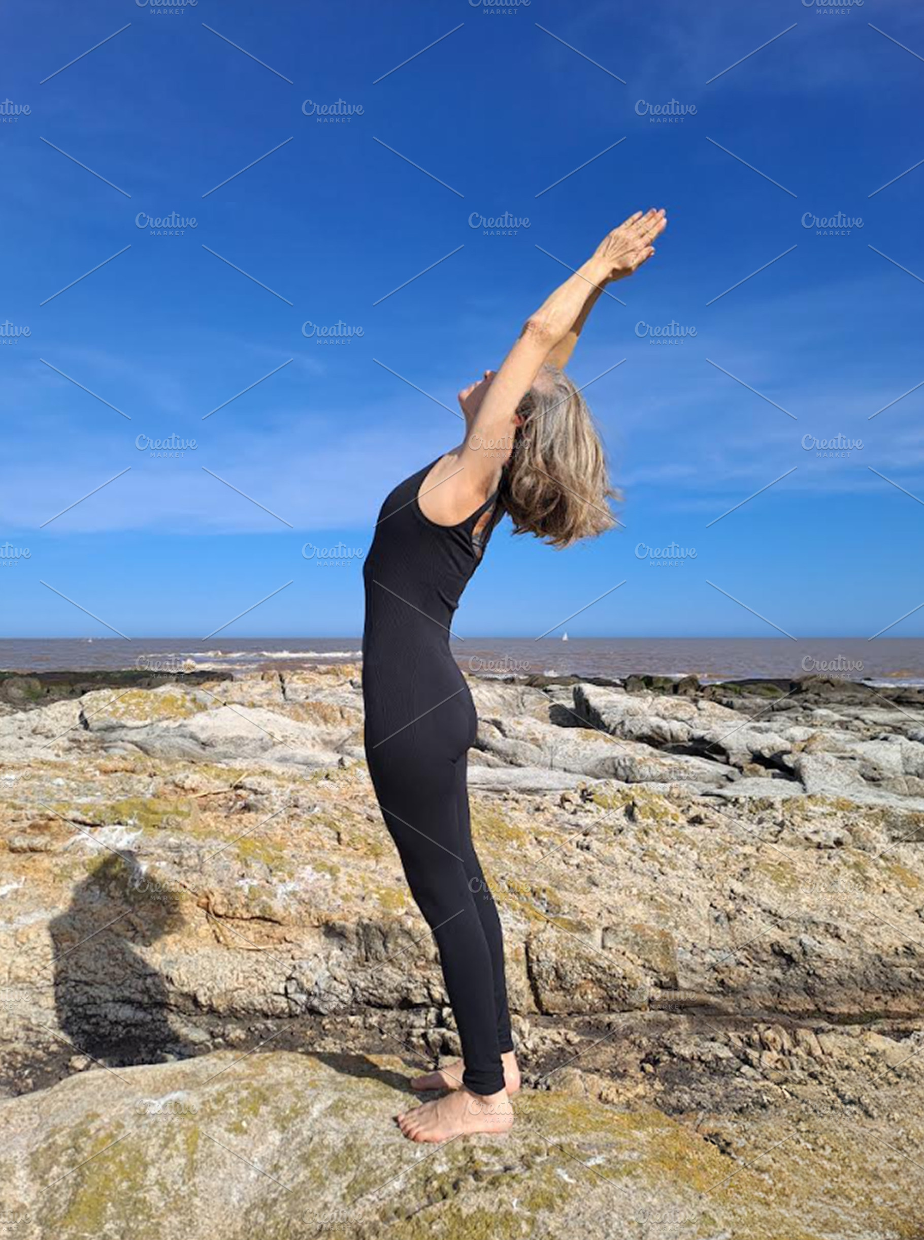 Woman practices pilates on a rugged rocky surface, a Sports & Recreation Photo by DanFLCreativo