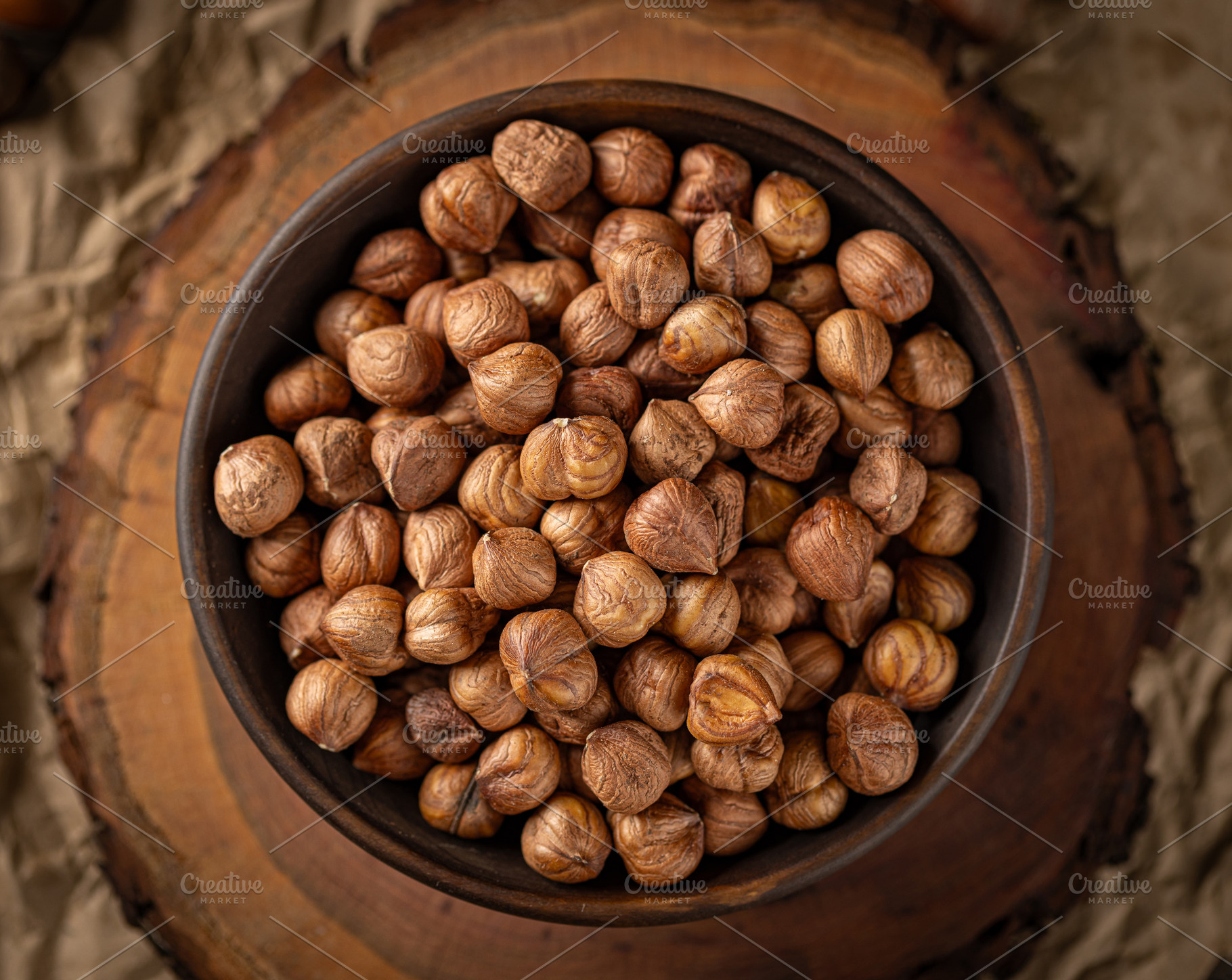 Roasted hazelnuts piled in a bowl, a Photo by Grafvision photography