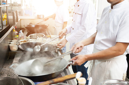 Group of chefs in hotel or restaurant kitchen busy cooking stock photo, a Person Photo by Twinster Photo