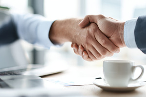 Two people shake hands in an office, a Photo by Beautiful things