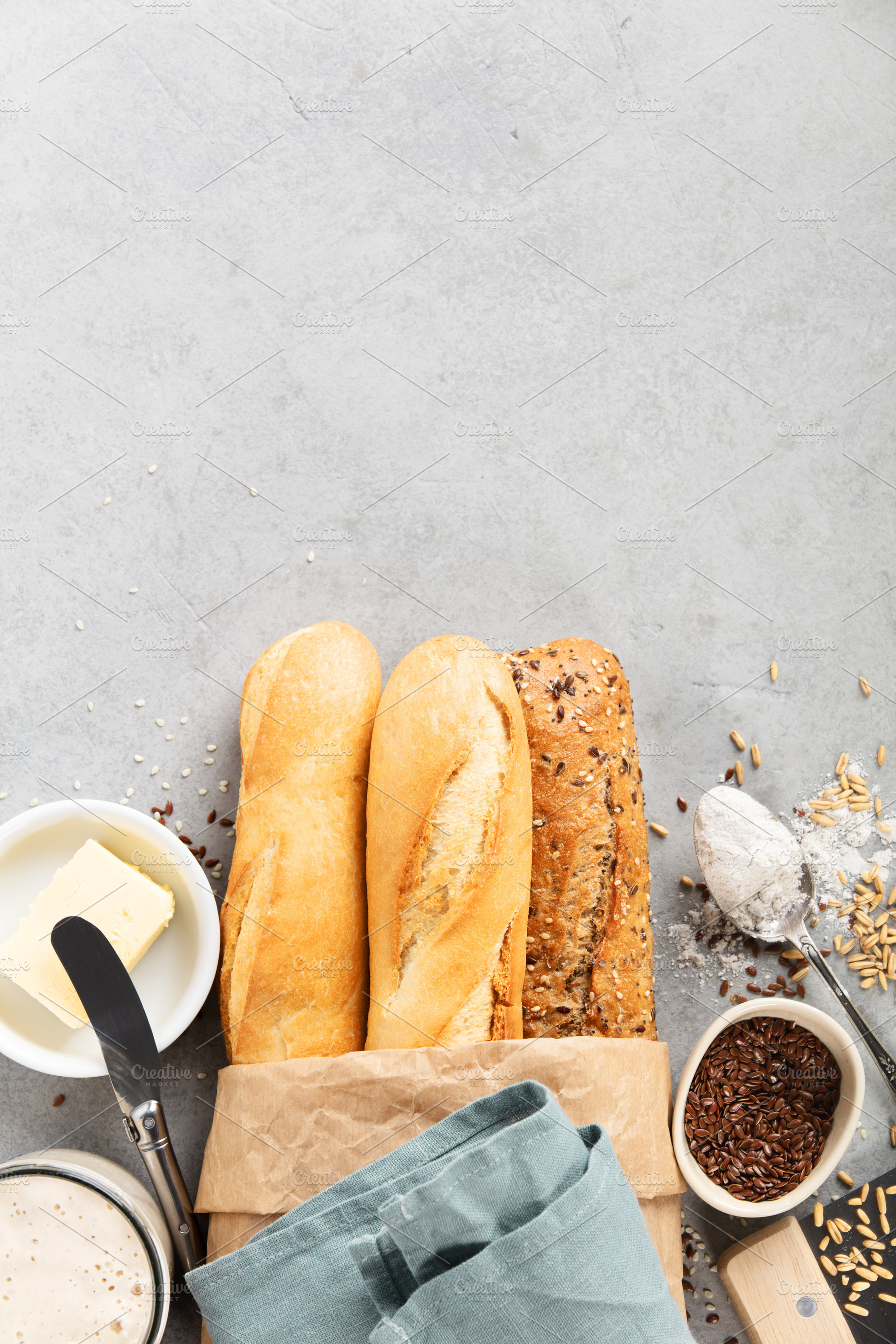 Assorted Baguettes with Butter, Flour, and Seeds on Table, a Food & Drink Photo by Natalia Klenova's Shop