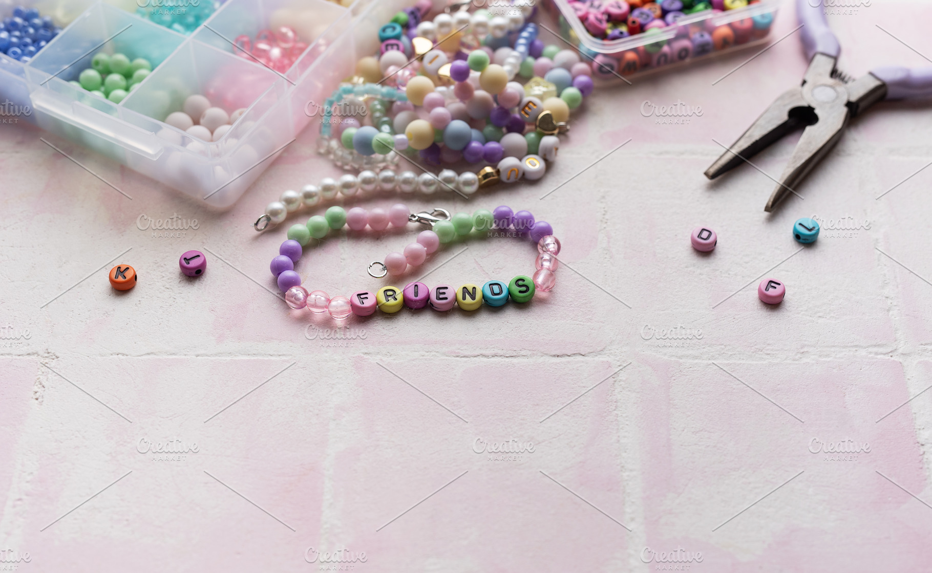 Colorful beads and pliers arranged on pink tile for jewelry maki, an Arts & Entertainment Photo by Olena Rudo
