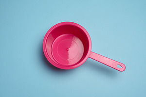 Empty pink plastic ladle on blue background, a Food & Drink Photo by ndanko