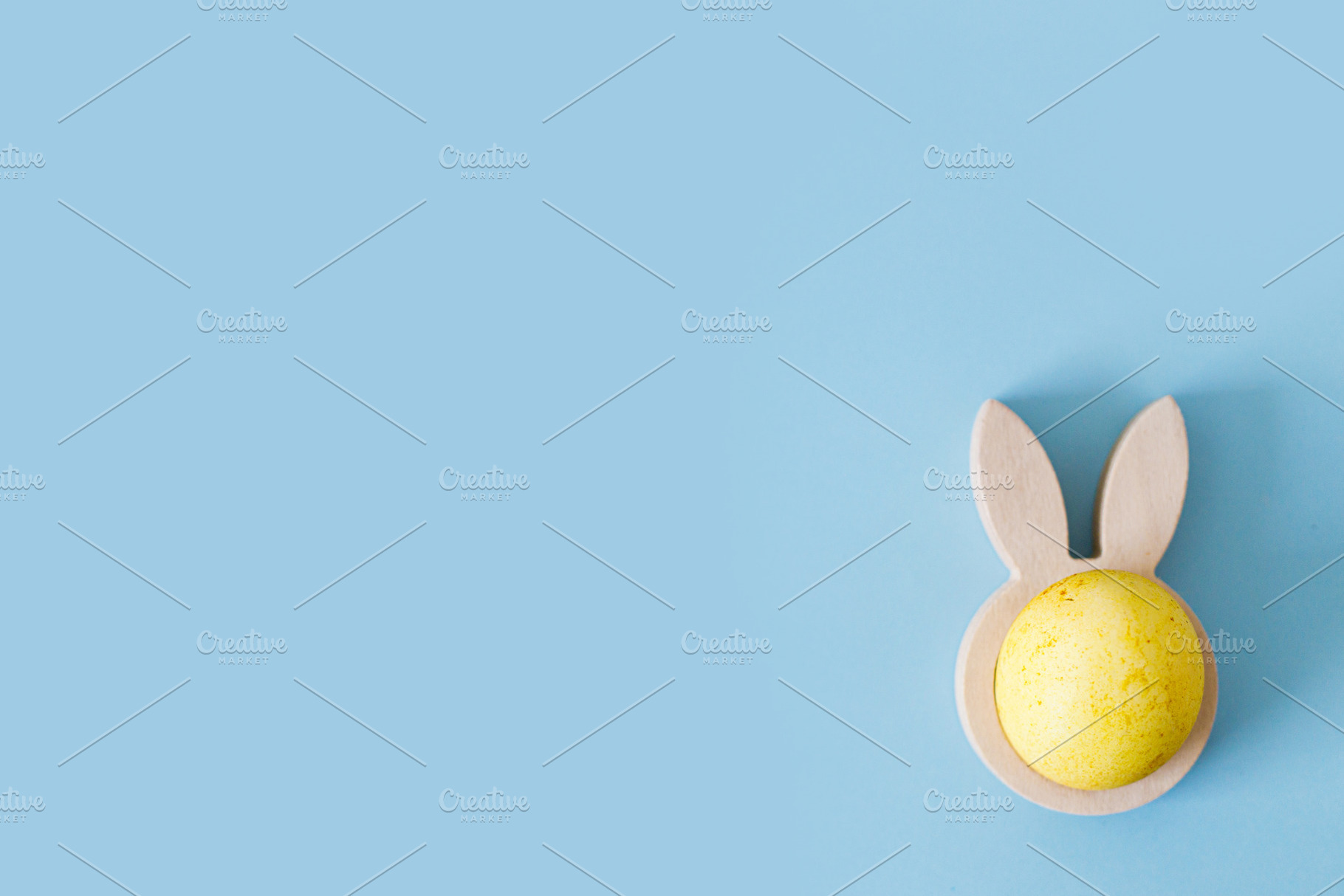 Easter flat lay. Stylish easter egg in wooden bunny ears holder, a Holiday Photo by Sonjachni