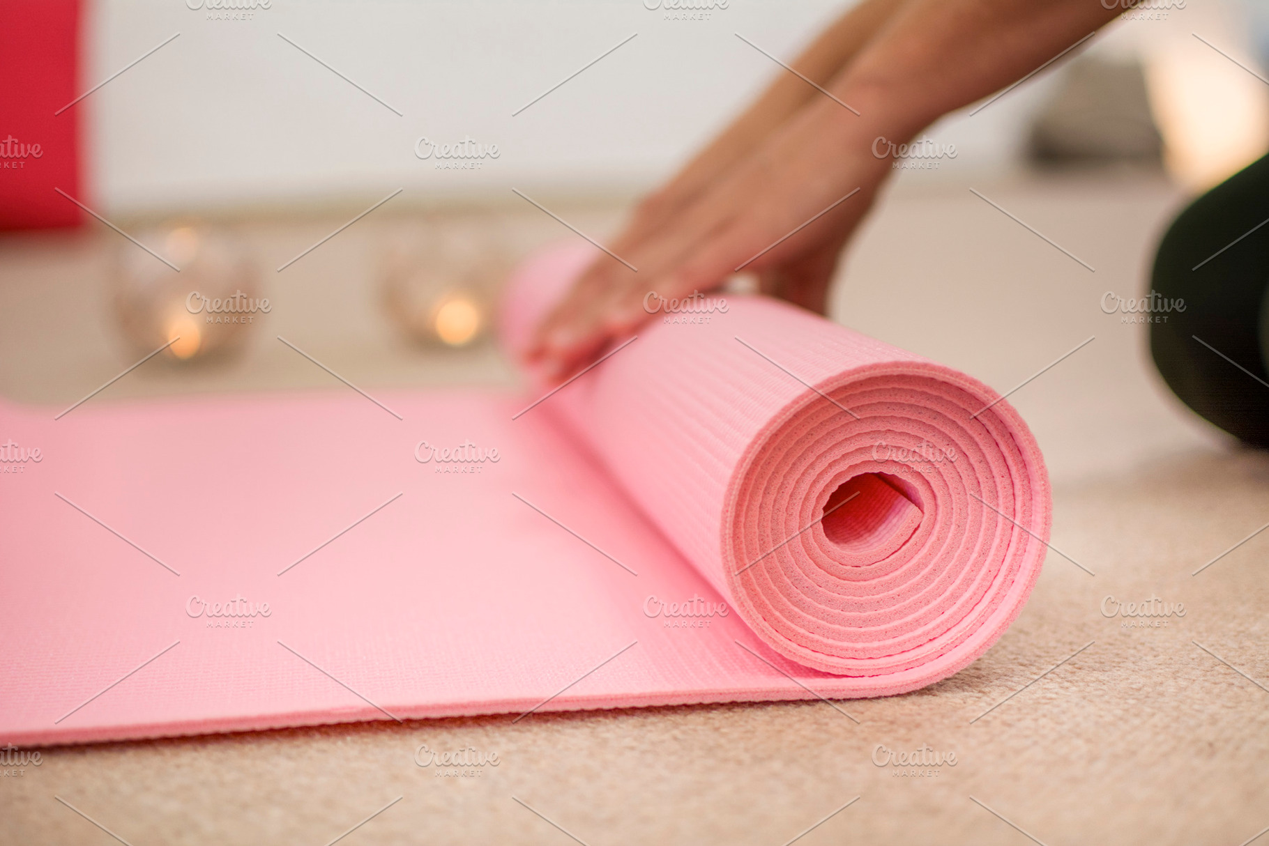 Hands winding the pink yoga mat, a Sports & Recreation Photo by RaquelVizcaíno