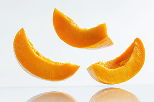 Floating orange pumpkin slices captu, a Photo by Tanuart