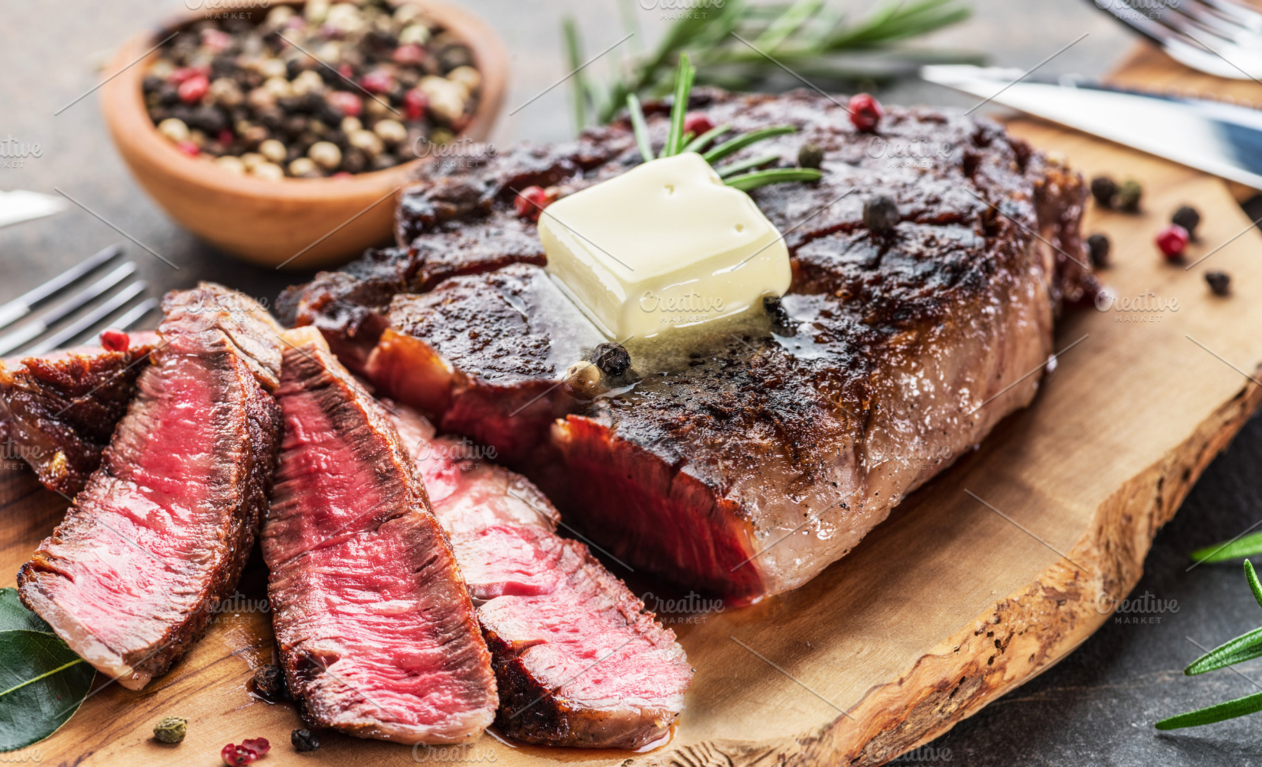 Grilled medium rare ribeye steak slices with melting butter on w, a Food & Drink Photo by Volff