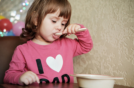 Cute Little Girl 2 Years alone eats porridge with a spoon., a Person Photo by Rohan Photography
