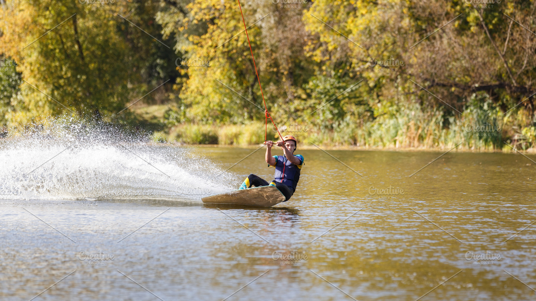 Young wakeboarder surfing along the river, a Sports & Recreation Photo by serkum