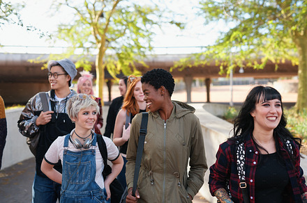 group of college students leaving campus friends walking together hanging out in city urban people, a Photo by Peopleimages.com