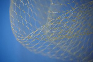 Abstract wave of yellow nylon mesh against a bright blue sky. Close-up of decor, an Abstract Photo by Rohan Photography