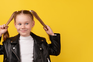 Smiling young girl in black leather jacket playfully holding her, a Person Photo by Ales Munt