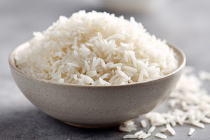 Bowl of cooked white rice on a gray, a Food & Drink Photo by MistyDay