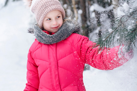 Little girl in a bright jacket plays in the winter forest, a Person Photo by Olena Rudo