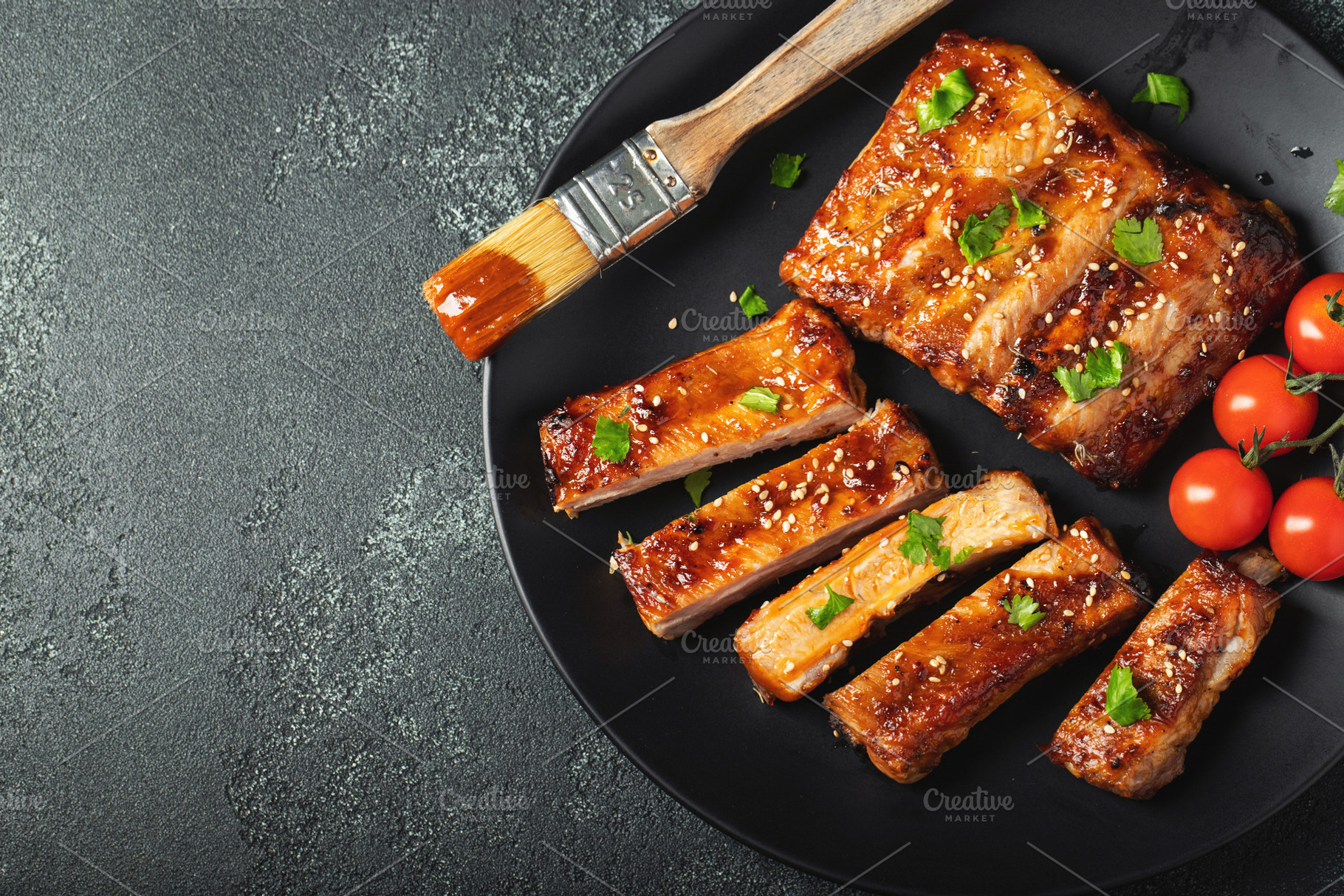 Hot grilled spare ribs from a summer BBQ served on a plate with sauce. Top view, a Food & Drink Photo by Budarinphoto