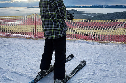 Person skiing at high altitude with scenic mountain view, a Photo by AS photostudio