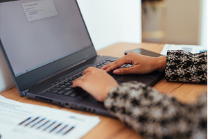 Woman sitting at desk typing, a School & Education Photo by undrey
