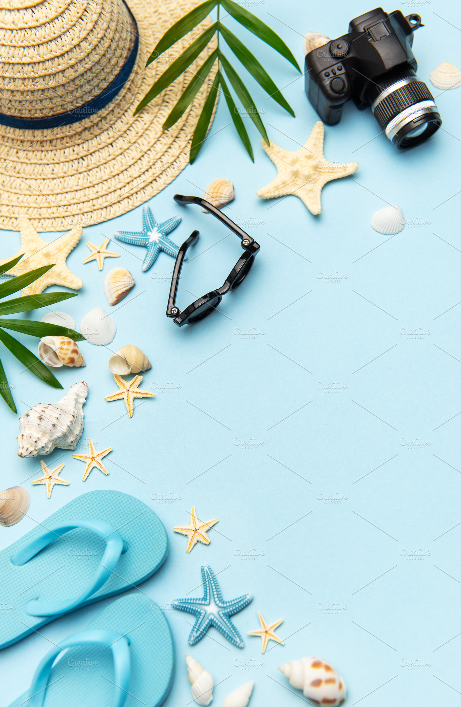 Summer accessories creating frame on light blue background with, a Holiday Photo by Olena Rudo