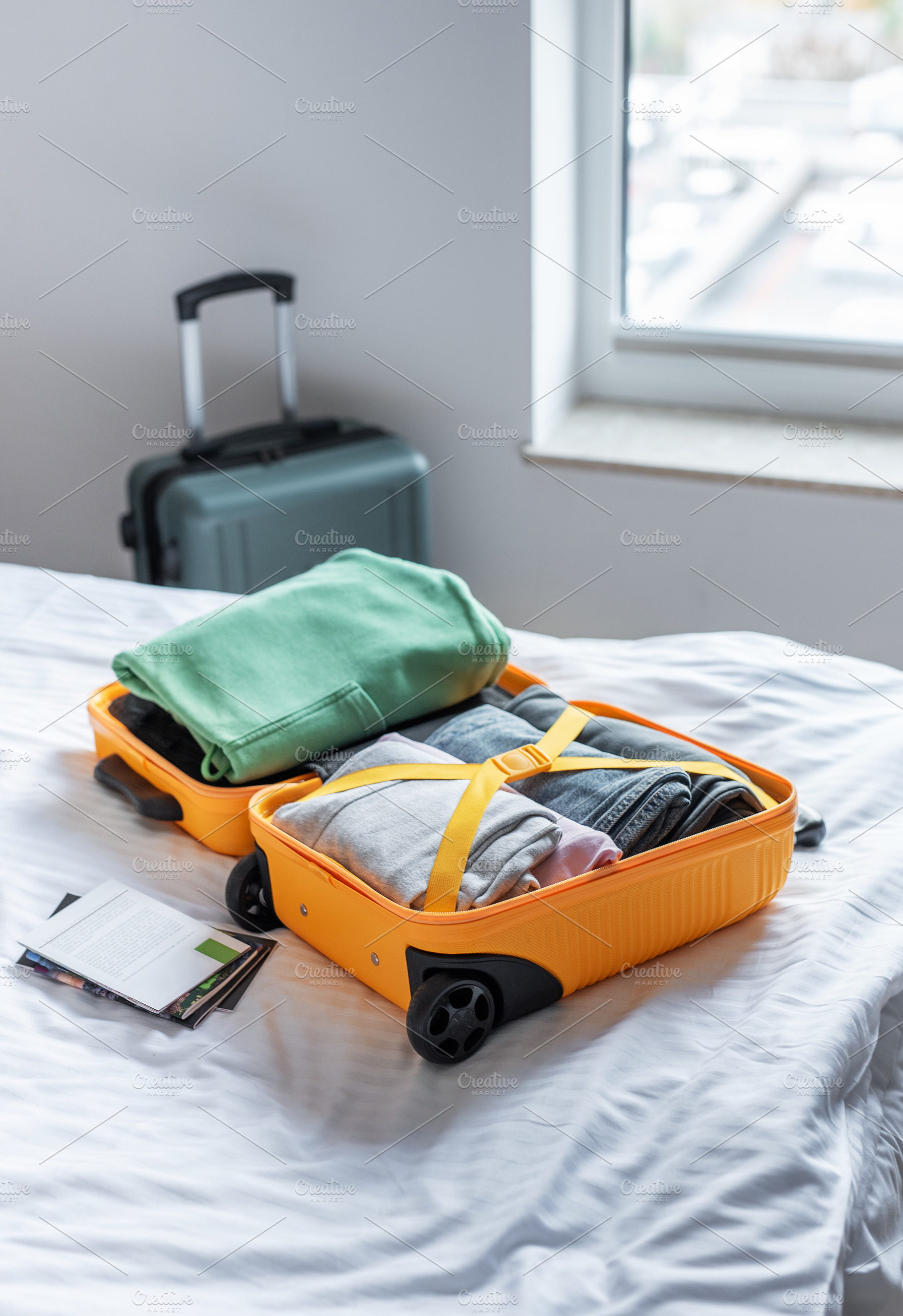 Open suitcase filled with clothes packing for travel, a Holiday Photo by Olena Rudo