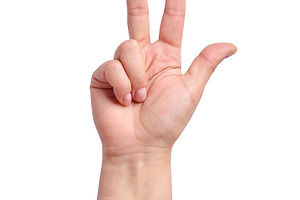 A woman's hand in a pink sleeve shows a gesture with three finge, a Person Photo by ndanko