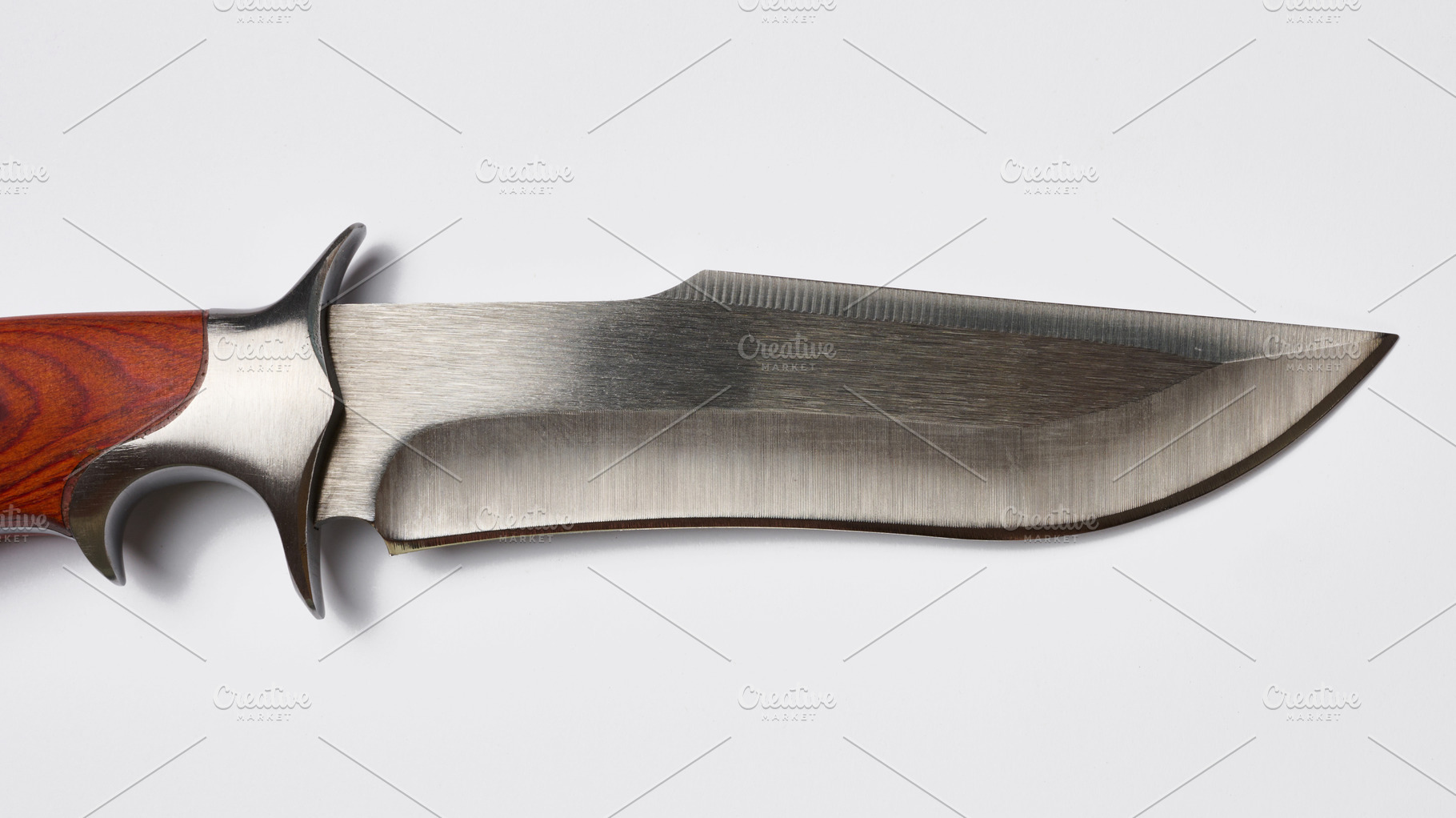 Close-up of a hunting knife blade and guard with a wooden handle, an Abstract Photo by ndanko