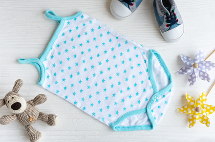 Blue romper  with knittes toy dog, toy windmills  and baby shoes, a Beauty & Fashion Photo by Olena Rudo